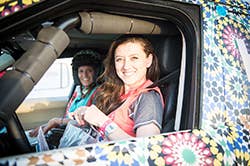 Smiling Rallye Aicha Des Gazelles competitors in their truck
