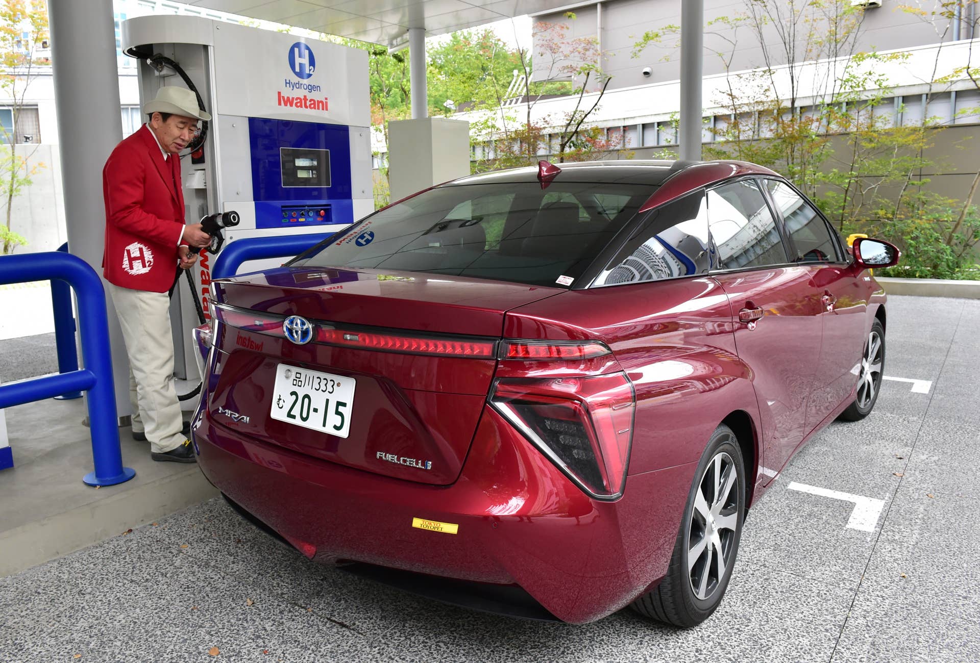 TO GO WITH AFP STORY: Climate-warming-COP21-Japan-hydrogen, FOCUS by Anne Beade Japan's gas distributor Iwatani's serviceman charge hydrogen gas to Japanese auto giant Toyota Motor's fuel cell vehicle Mirai at Iwatani's hydrogen station in Tokyo on October 29, 2015. Japan has lofty visions of becoming a 'hydrogen society' where homes and fuel-cell cars are powered by the emissions-free energy source, but observers say cost, convenience and policy hurdles are preventing the plan from taking off. Tokyo wants to see buses, buildings and cars powered by the clean energy in the coming years, and has even laid out plans for a 'hydrogen highway', all in time for the Tokyo 2020 Olympics. AFP PHOTO / Yoshikazu TSUNO (Photo credit should read YOSHIKAZU TSUNO/AFP/Getty Images)