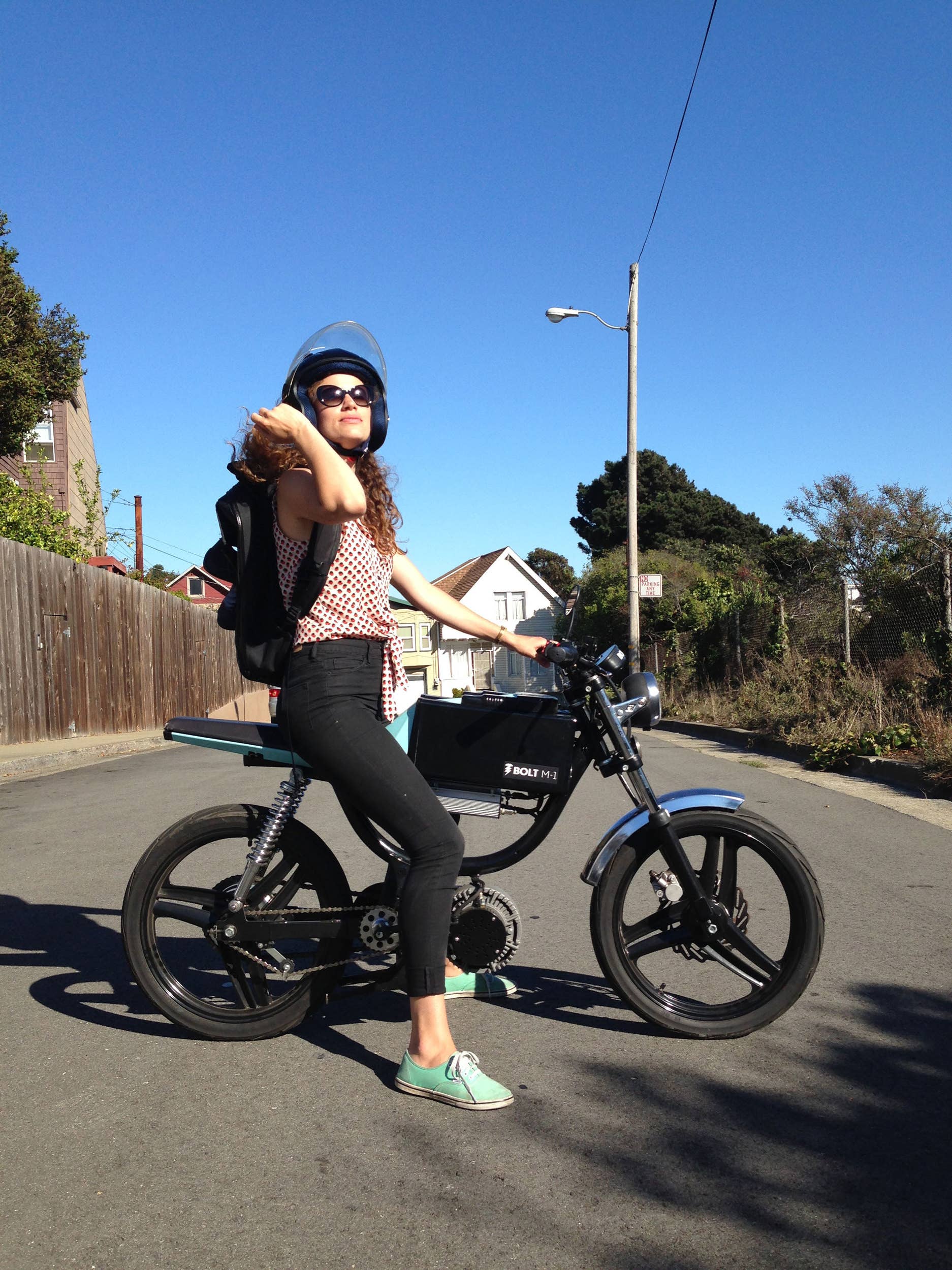 Bolt Motorbikes M-1 electric moped on the street with female rider