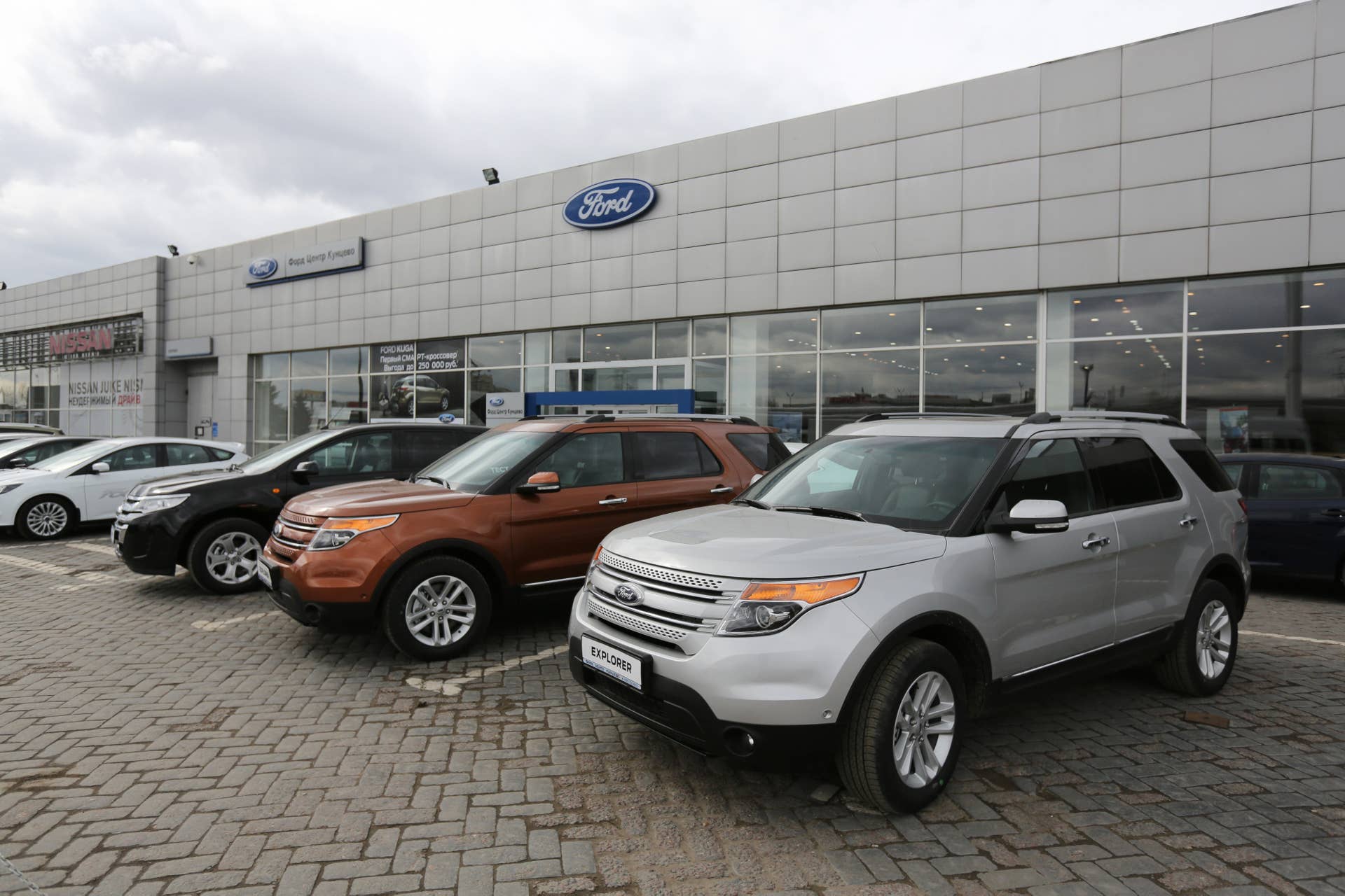 New Ford Focus MkIII compact cars, right, and Ford Mondeo, left, vehicles sit for sale on a sidewalk outside a Ford Motor Co. automobile dealership in Moscow, Russia, on Thursday, April 3, 2014. Ford Russian joint venture is cutting about 950 jobs at two factories in response to the falling ruble and deteriorating demand in the country. Photographer: Andrey Rudakov/Bloomberg via Getty Images
