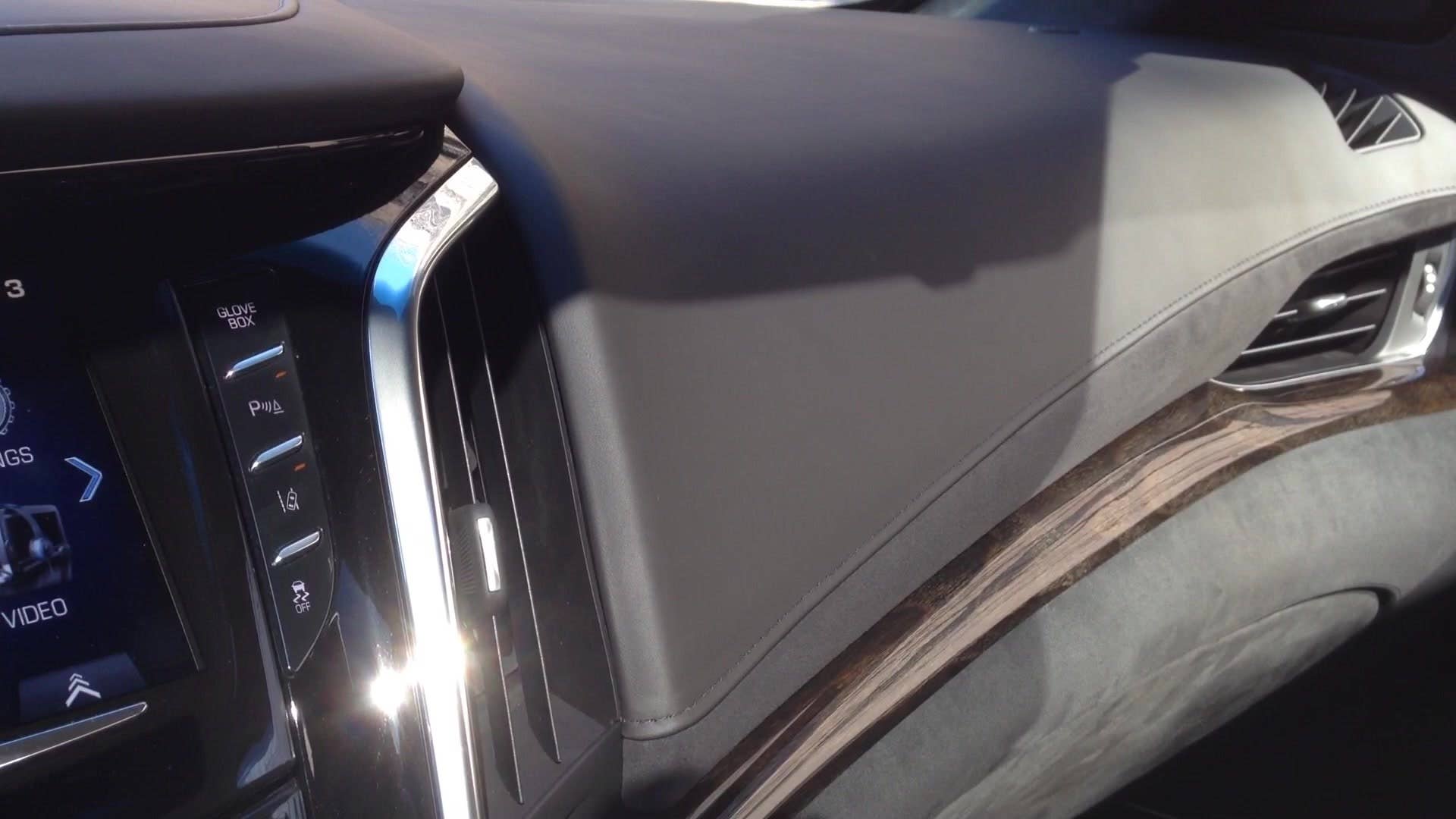 Senior editor Greg Migliore shows off the push-button glove box in the 2015 Cadillac Escalade.