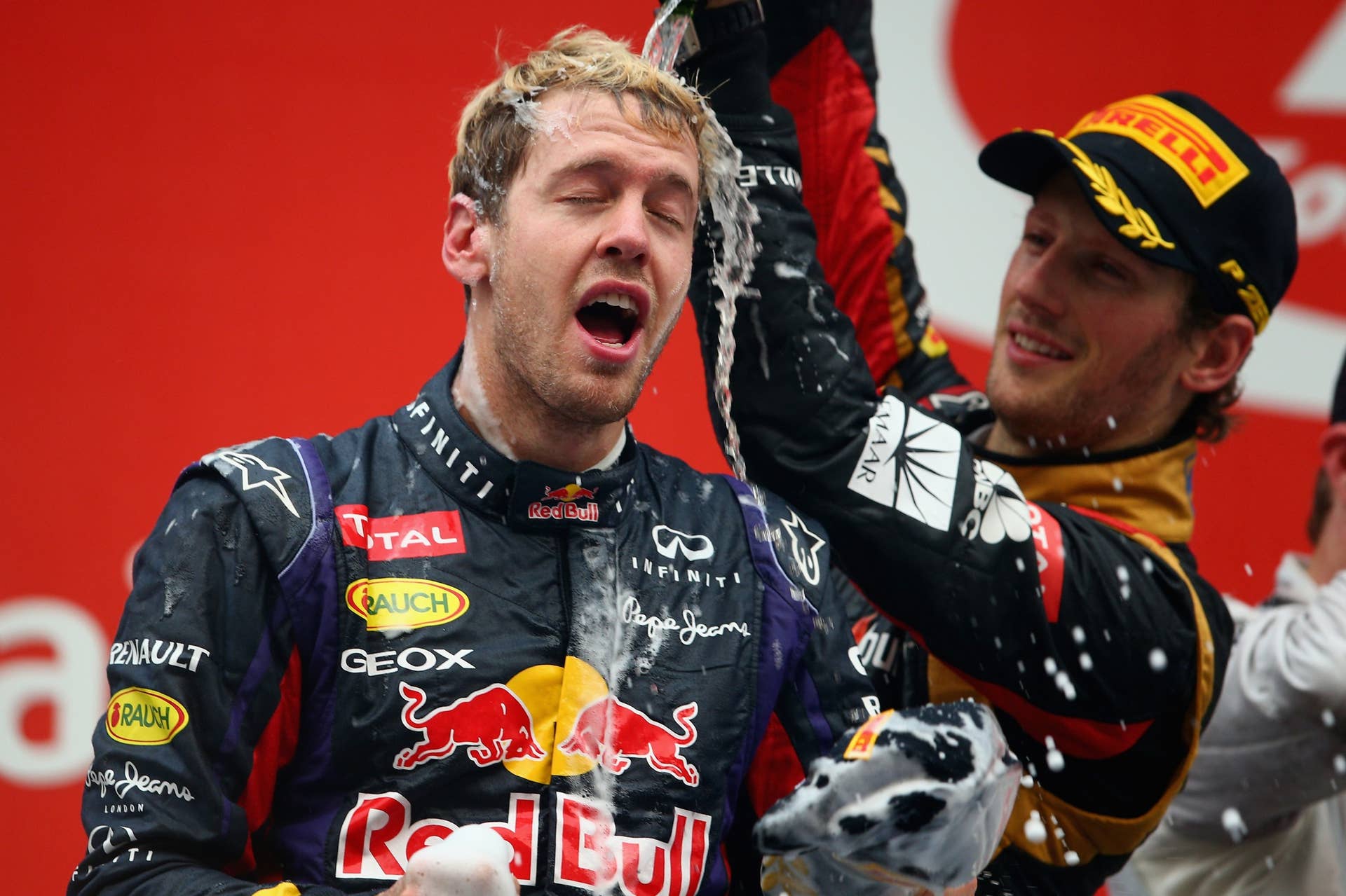 NOIDA, INDIA - OCTOBER 27:  Race winner and 2013 Formula One World Champion Sebastian Vettel (L) of Germany and Infiniti Red Bull Racing celebrates with third placed Romain Grosjean (R) of France and Lotus following the Indian Formula One Grand Prix at Buddh International Circuit on October 27, 2013 in Noida, India.  (Photo by Paul Gilham/Getty Images)