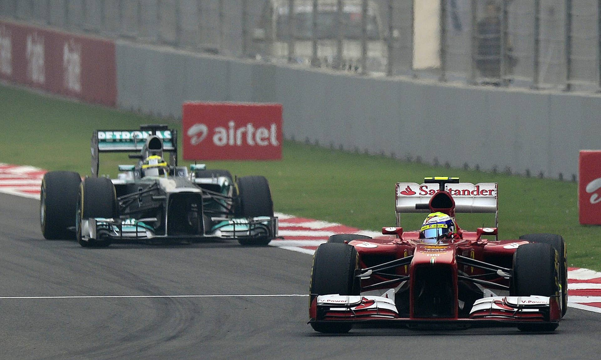 Ferrari driver Felipe Massa (R) powers ahead of Mercedes driver Nico Rosberg of Germany during the Formula One Indian Grand Prix 2013 in Greater Noida, on the outskirts of New Delhi on October 27, 2013.  AFP PHOTO/MANAN VATSYAYANA        (Photo credit should read MANAN VATSYAYANA/AFP/Getty Images)