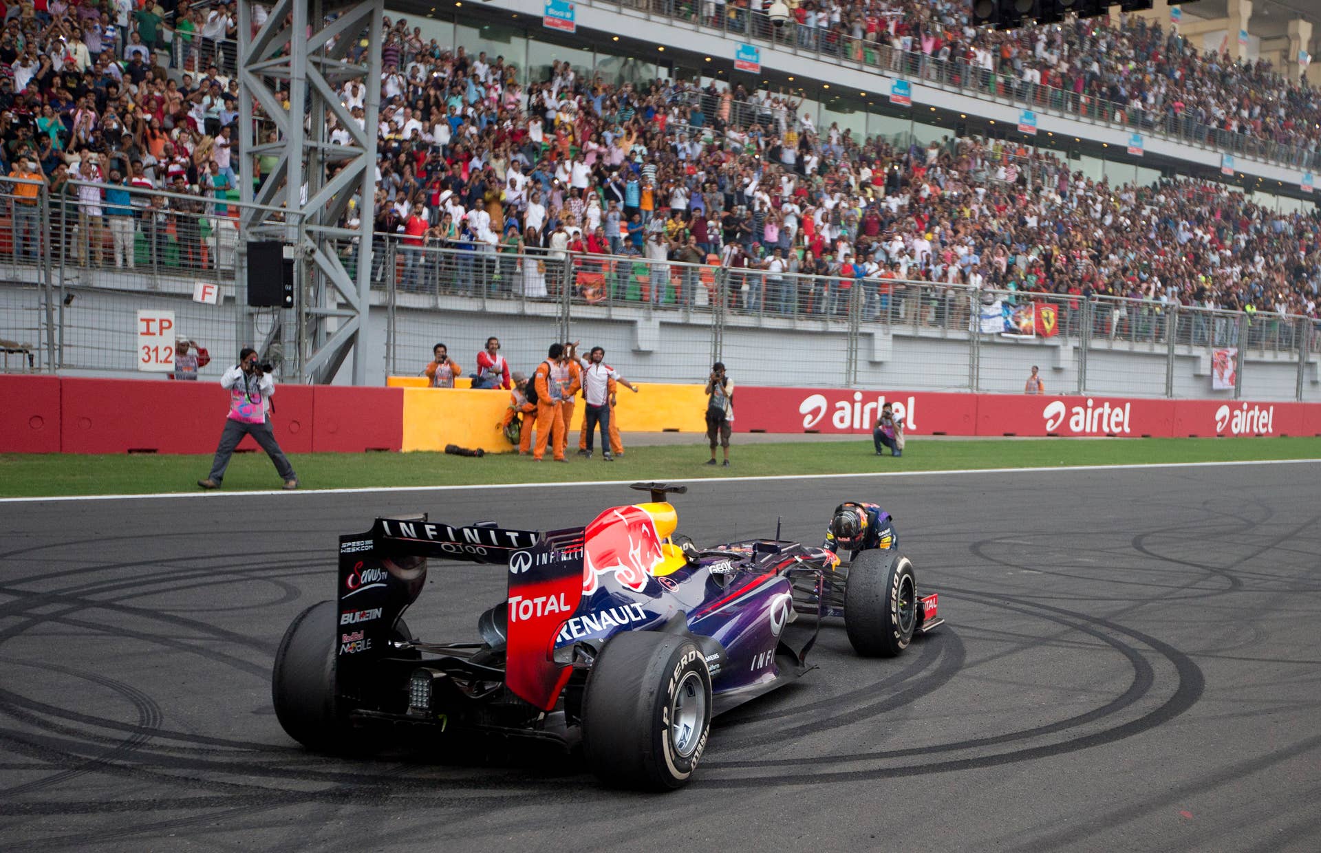 Red Bull driver Sebastian Vettel of Germany celebrates on the track after winning the Indian Formula One Grand Prix and his 4th straight F1 world drivers championship at the Buddh International Circuit in Noida, India, Sunday, Oct. 27, 2013. (AP Photo/Mark Baker)