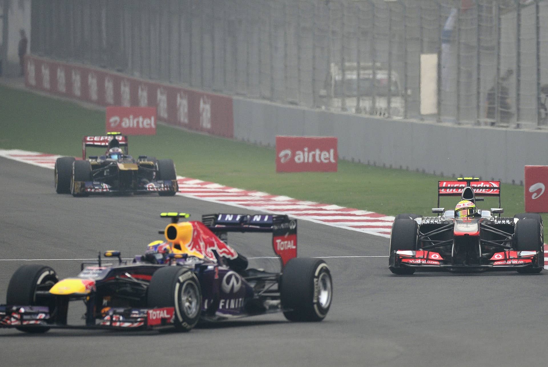 Red Bull driver Mark Webber of Australia (R) drives his car followed by McLaren driver Sergio Perez Mendoza of Mexico (R) during the Formula One Indian Grand Prix 2013 at the Buddh International circuit in Greater Noida, on the outskirts of New Delhi on October 27, 2013.  AFP PHOTO/ MANAN VATSYAYANA        (Photo credit should read MANAN VATSYAYANA/AFP/Getty Images)