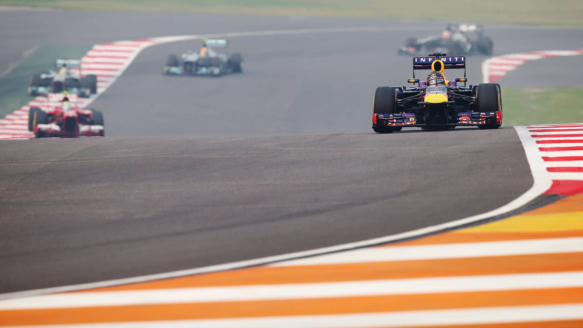 NOIDA, INDIA - OCTOBER 27:  Sebastian Vettel of Germany and Infiniti Red Bull Racing leads the field on lap one of the Indian Formula One Grand Prix at Buddh International Circuit on October 27, 2013 in Noida, India.  (Photo by Clive Mason/Getty Images)