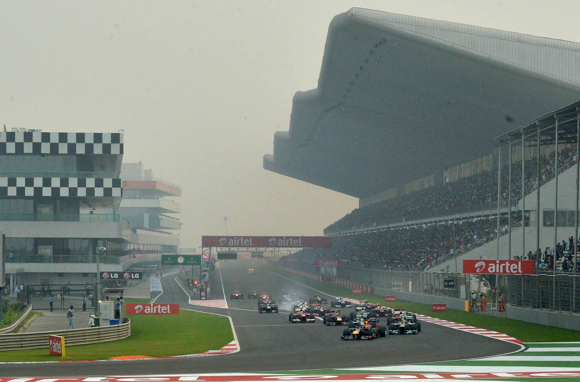Red Bull driver Sebastian Vettel of Germany (C) leads the pack during the Formula One Indian Grand Prix 2013 in Greater Noida, on the outskirts of New Delhi on October 27, 2013.  AFP PHOTO/MANAN VATSYAYANA        (Photo credit should read MANAN VATSYAYANA/AFP/Getty Images)