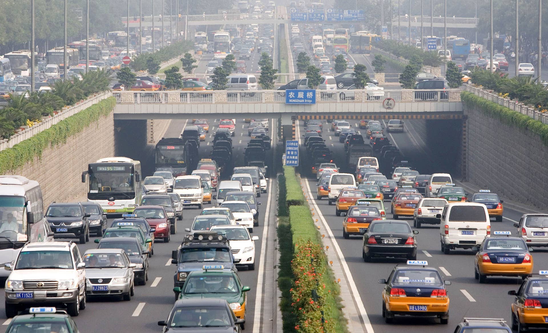 Cars drive during peak hour traffic on a major highway on the first day of a test to reduce car numbers in Beijing, China, Friday, Aug. 17, 2007. City officials yanked hundreds of thousands of private cars off Beijing's streets Friday to test whether a partial car ban could clear health-threatening smog and ease gridlock during next year's Olympic Games. (AP Photo/Ng Han Guan)