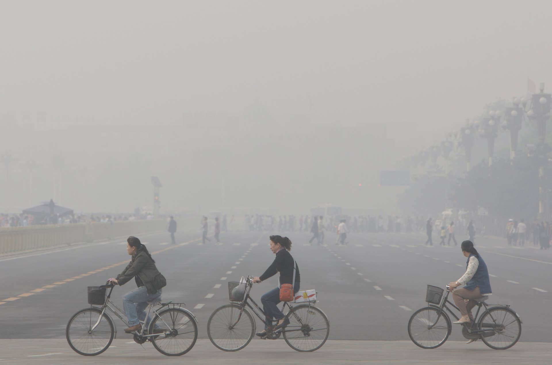 ** FILE ** Chinese cycle through smog and pollution over Beijing's Tiananmen Square Thursday , May 1, 2008. Beijing's Olympic shutdown begins Sunday, July 20, 2008, a drastic plan to lift the Chinese capital's gray shroud of pollution just three weeks ahead of the games.(AP Photo/Oded Balilty)