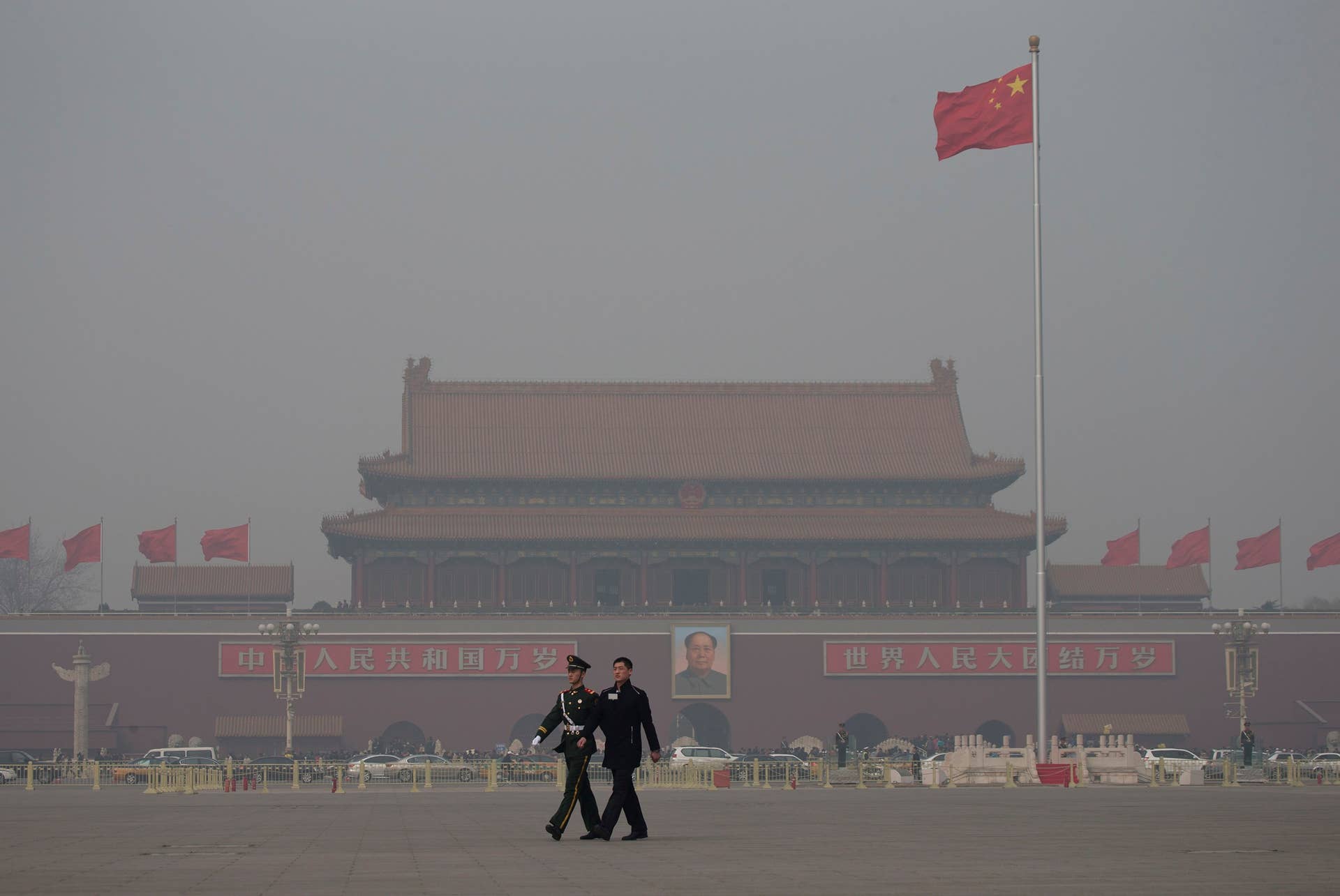 In this Friday, March 8, 2013 Chinese paramilitary policemen march across Tiananmen Square on a hazy day in Beijing, China. Facing public outrage over smog-choked cities and filthy rivers, China's leaders are promising to clean up its neglected environment, a pledge that sets up a clash with political pressures to keep economic growth strong.  (AP Photo/Andy Wong)