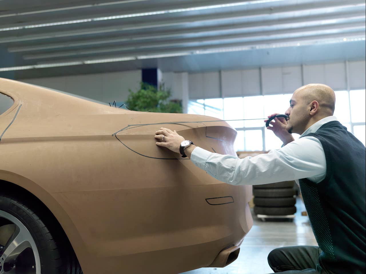 Nader Faghizadeh (Exterior Designer BMW 6 Series Coupe) taping a foiled clay model of the BMW 6 Series Coupe (03/2011).