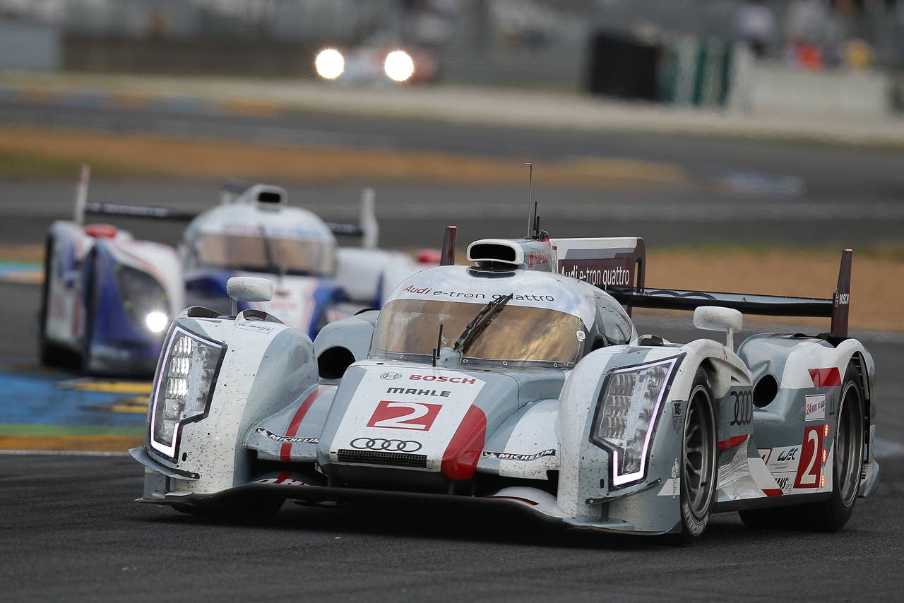The Audi R18 E-Tron n2 driven by Allan McNish of Scotland, Rinaldo Capello of Italy and Tom Kristensen of Denmark powers in a curve ahead of the Toyota n7 during the qualifying practice session of the 80th 24-hour Le Mans endurance race, in Le Mans, western France, Thursday, June 14, 2012. The race will begin on Saturday, June 16. (AP Photo/David Vincent)