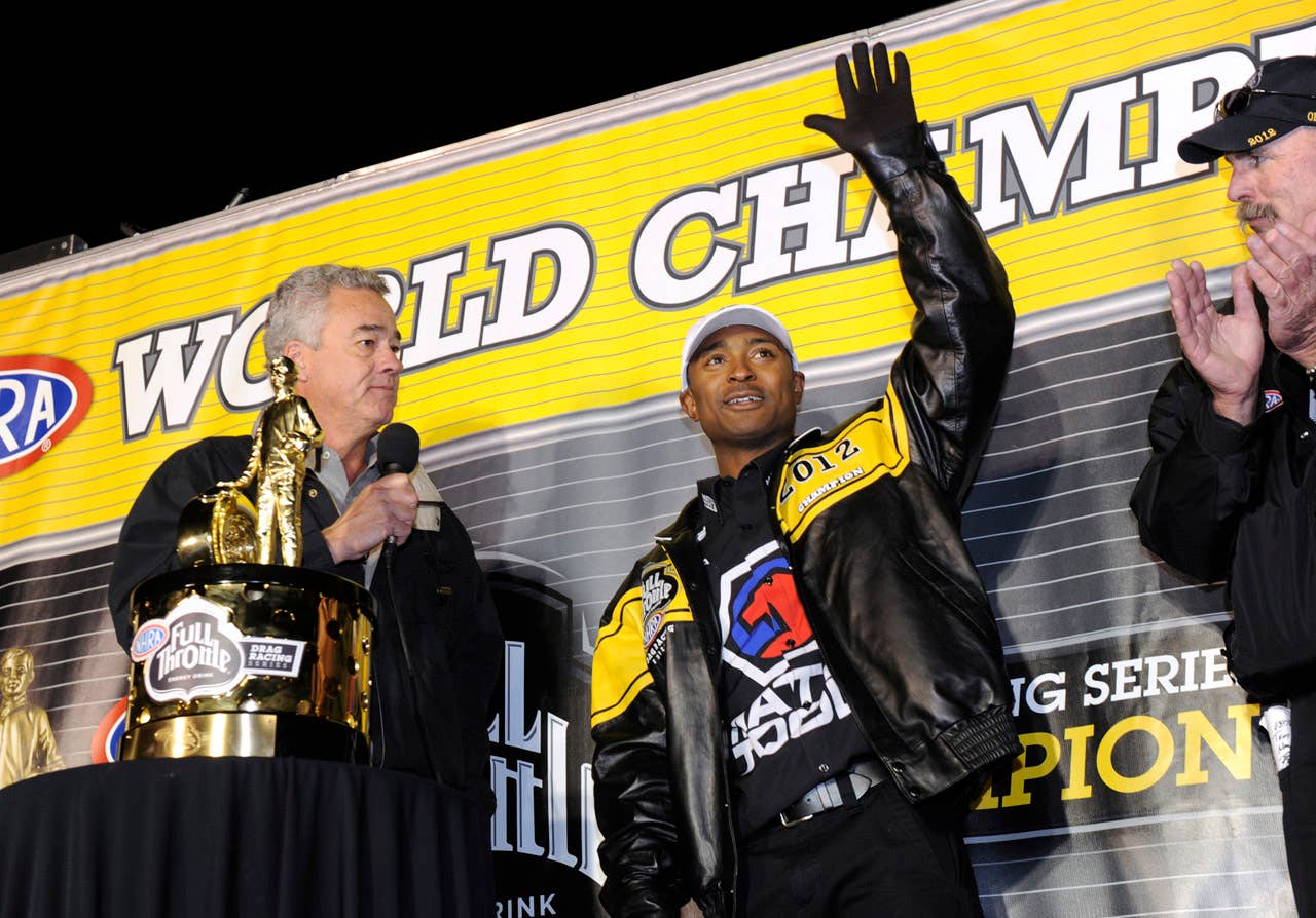 In this photo provided by NHRA, Top Fuel world champion Antron Brown, right, is congratulated by NHRA President Tom Compton after Brown became the first black champion to win a major U.S. auto racing title at the Auto Club NHRA auto race finals on Sunday, Nov. 11, 2012, in Pomona, Calif. (AP Photo/NHRA, Marc Gewertz)