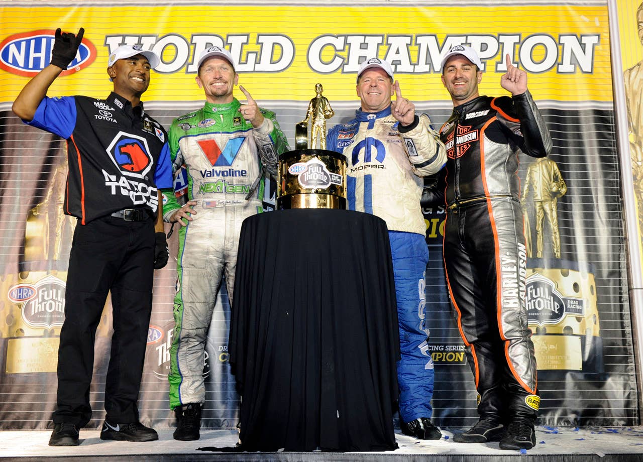 In this photo provided by NHRA, the NHRA Full Throttle Drag Racing Series world champions, from left, Antron Brown (Top Fuel), Jack Beckman (Funny Car), Allen Johnson (Pro Stock) and Eddie Krawiec celerbate during a news conference at the Auto Club NHRA auto race finals on Sunday, Nov. 11, 2012, in Pomona, Calif. (AP Photo/NHRA, Marc Gewertz)