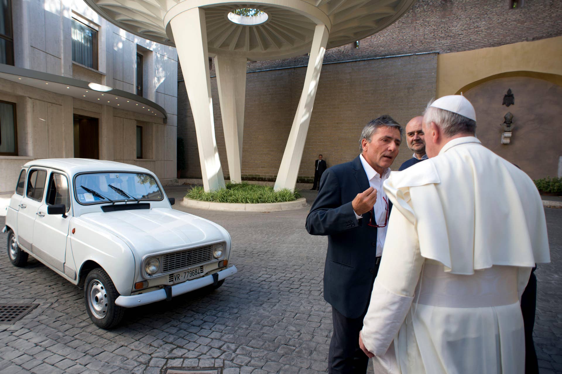 In this Saturday, Sept. 7, 2013 picture made available by the Vatican newspaper l'Osservatore Romano, Pope Francis looks at a Renault 4L donated to him by Rev. Renzo Zocca, not pictured, as he speaks with Zocca's assistant Luigi Macchioni, left, at the Vatican. Rev. Zocca, 70, told the Associated Press on Wednesday, Sept. 11, 2013 that he has dedicated his life to helping the needy on the outskirts of Verona, so when he saw that Pope Francis' priority was to reach out to the world's poor and inspire the Catholic leaders to go to slums and peripheries to preach, he decided to donate what he calls his 25-year-old "car of the French farmers" as a symbol of this approach. The pontiff invited Rev. Zocca for a private audience and on that occasion the priest had the car brought to the Vatican. (AP Photo/L'Osservatore Romano)