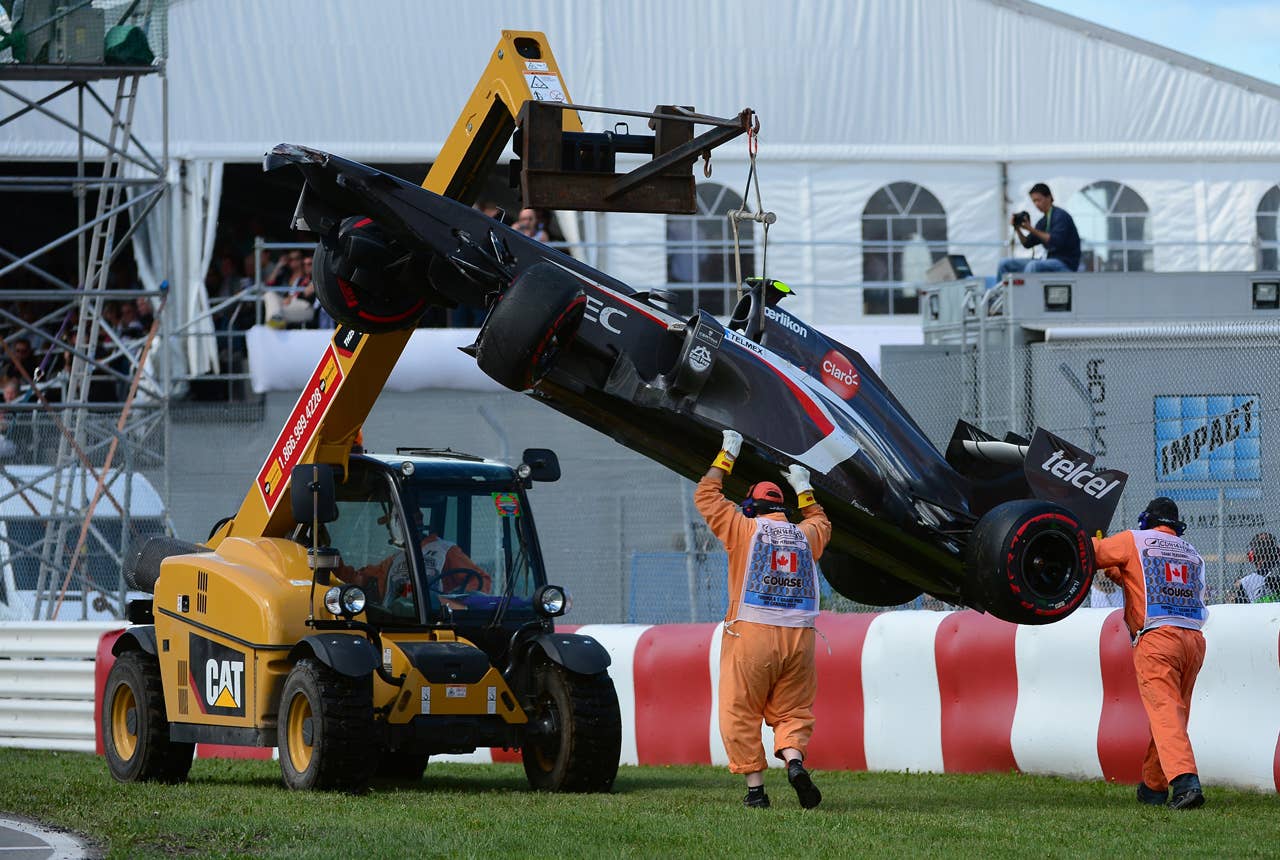 A crane lift Esteban Gutierrezs Sauber car at the end of the Canadian Formula One Grand Prix at the Circuit Gilles Villeneuve in Montreal, June 9, 2013.  A race-track worker at the Canadian Grand Prix was killed after he slipped under the wheel of the crane, officials said, as he was escorting the crane as it moved Esteban Gutierrezs Sauber car, following a crash.  AFP PHOTO/Emmanuel DunandEMMANUEL DUNAND/AFP/Getty Images