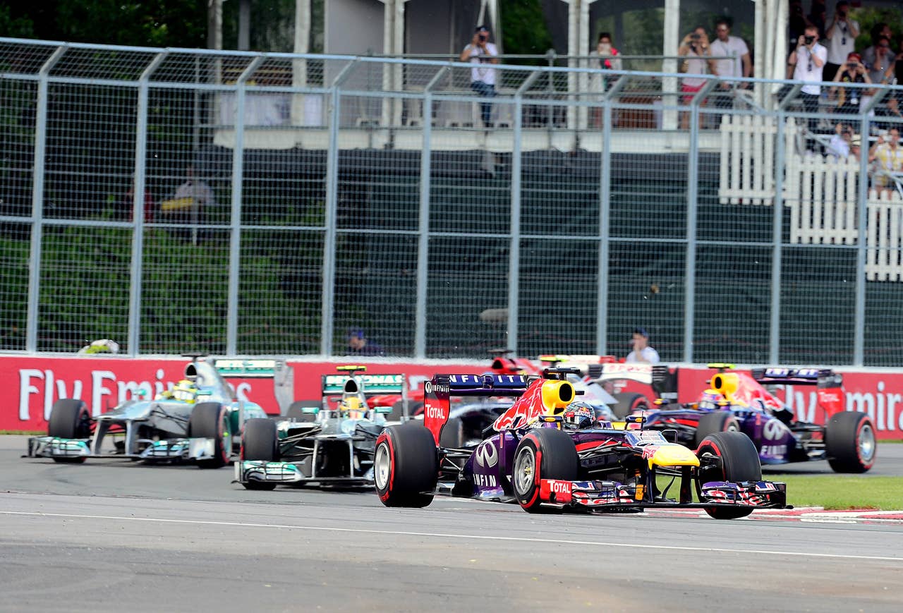 Red Bull driver Sebastian Vettel of Germany (R) leads the first lap of the Canadian Formula One Grand Prix at the Circuit Gilles Villeneuve in Montreal on June 9, 2013.    AFP PHOTO/Emmanuel DUNANDEMMANUEL DUNAND/AFP/Getty Images