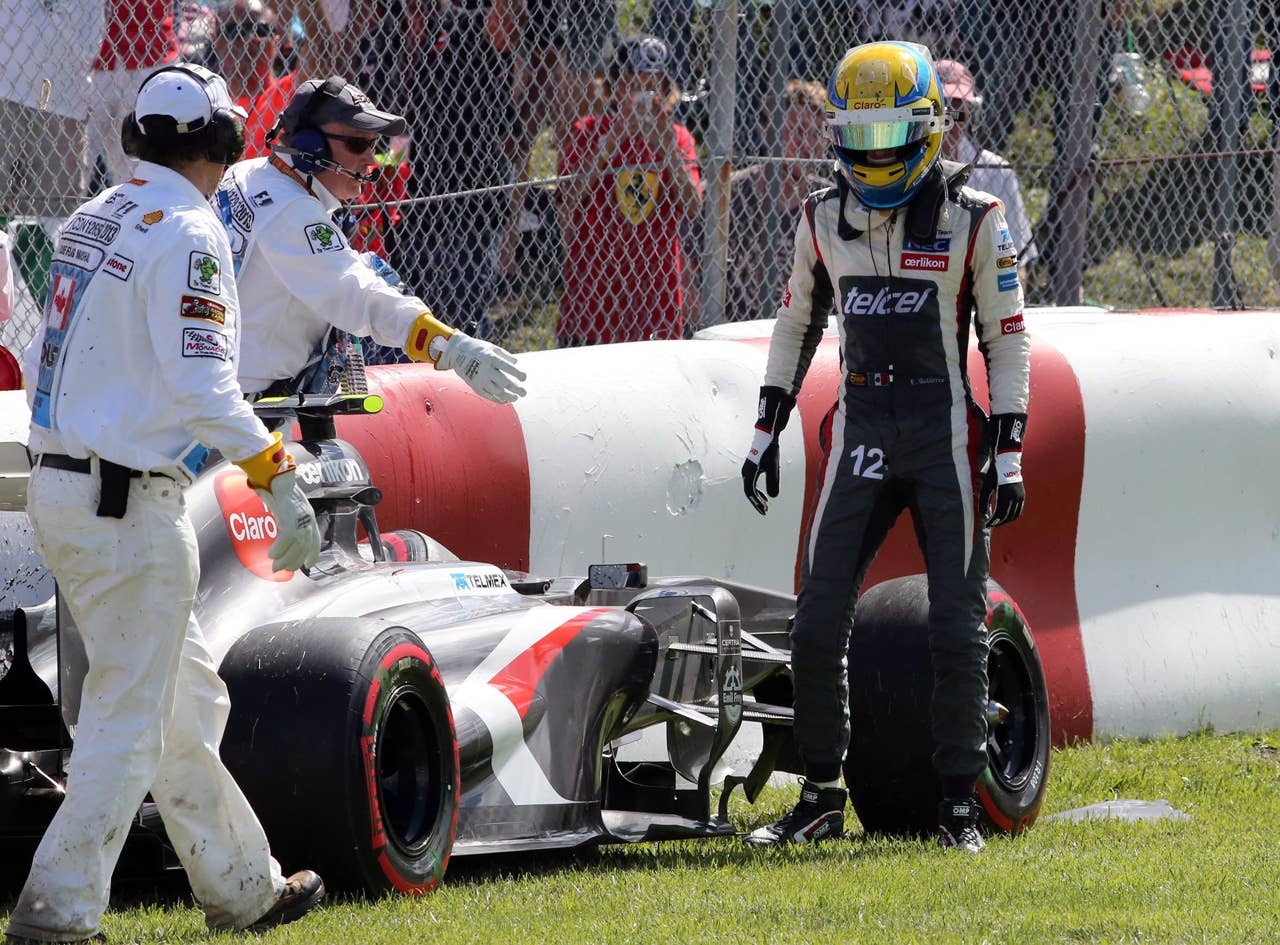 Sauber driver Esteban Gutierrez of Mexico looks at his car after crashing in the Senna corner at the Canadian Grand Prix, Saturday, June 8, 2013 in Montreal. (AP Photo/The Canadian Press, Tom Boland)