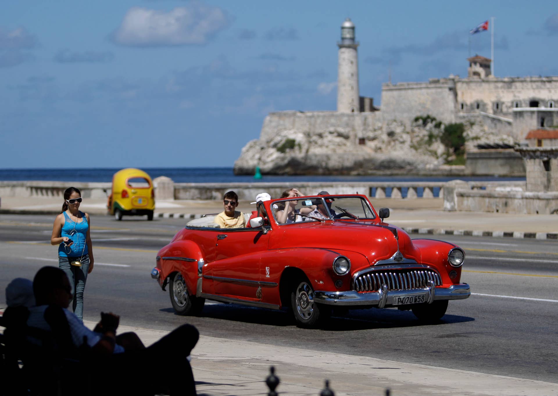In this Oct 12, 2013 photo, tourists ride in a classic American car on the Malecon in Havana, Cuba. (AP Photo/Franklin Reyes)