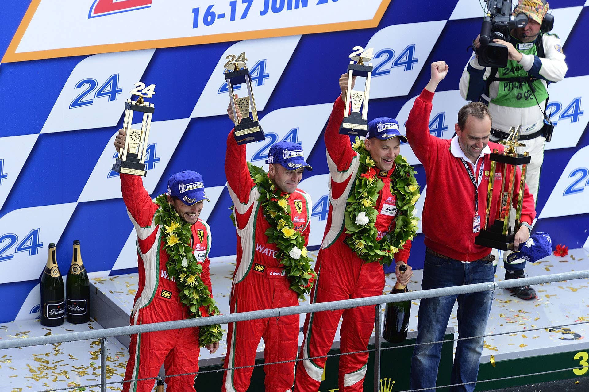 LE MANS, FRANCE - JUNE 17:  Giancarlo Fisichella of Italy, Gianmaria Bruni of Italy, and Toni Vilander of Finland celebrate on the podium after claiming GT class victory in their #51 AF Corse Ferrari 458 during the 80th running of the Le Mans 24 Hour race at the Circuit des 24 Heures du Mans  on June 17, 2012 in Le Mans, France. (Photo by Rick Dole/Getty Images)