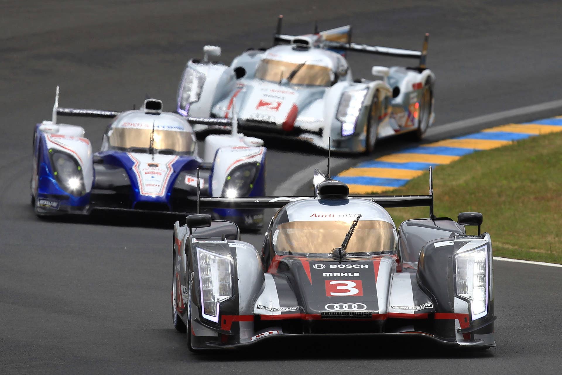The Audi R18 Ultra n3 driven by Marc Gene of Spain, Romain Dumas and Loic Duval both of France powers his car ahead of the Toyota n8 and the Audi n2 at the start of the 80th 24-hour Le Mans endurance race, in Le Mans, western France, Saturday, June 16, 2012. (AP Photo/David Vincent)