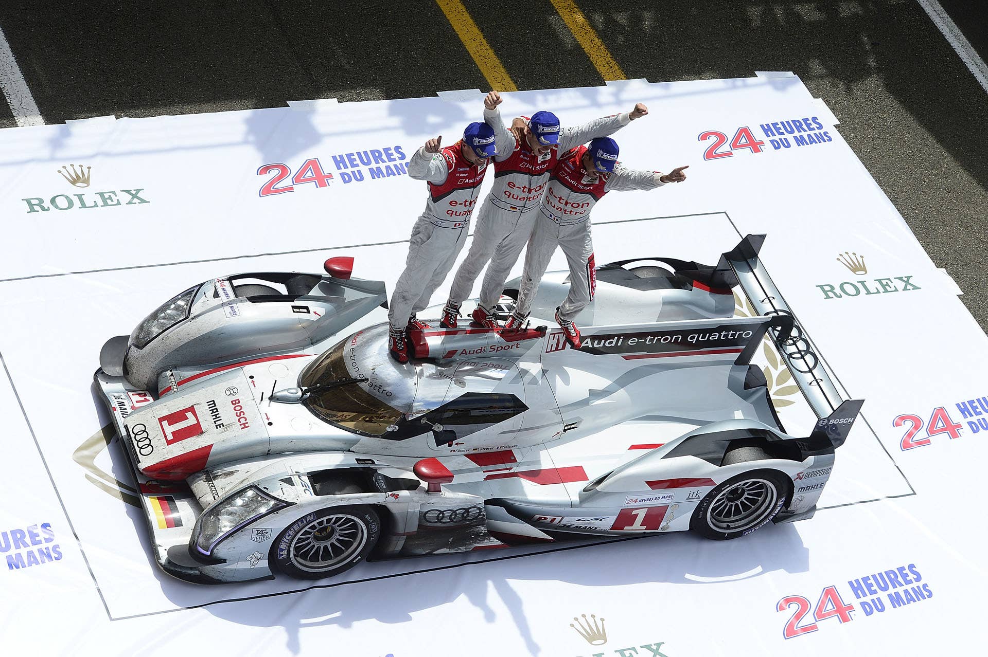 LE MANS, FRANCE - JUNE 17:  Marcel Fassler of Switzerland, Andre Lotterer of Germany, and Benoit Treluyer of France, celebrate in victory lane atop the #1 Audi e-tron quattro after winning the 80th running of the Le Mans 24 Hour race at the Circuit des 24 Heures du Mans  on June 17, 2012 in Le Mans, France. (Photo by Rick Dole/Getty Images)