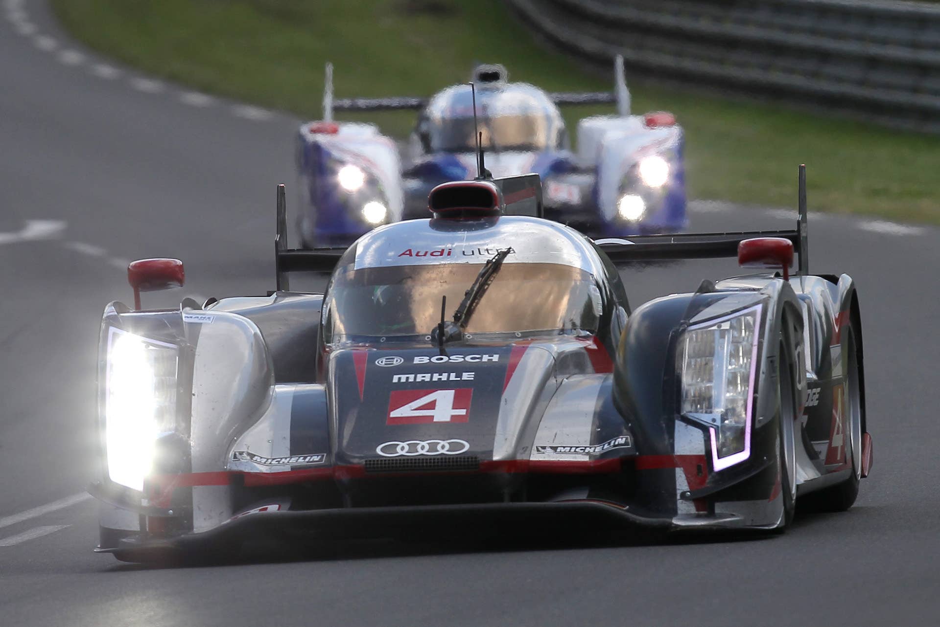 The Audi R18 Ultra no4 driven by Oliver Jarvis of Britain is seen in action ahead the Toyota n07 during the 80th 24-hour Le Mans endurance race, in Le Mans, western France, Saturday, June 16, 2012. (AP Photo/David Vincent)