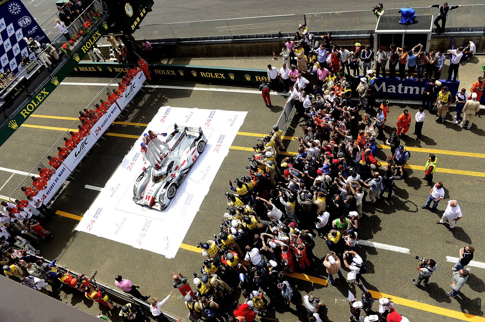 LE MANS, FRANCE - JUNE 17:  Marcel Fassler of Switzerland, Andre Lotterer of Germany, and Benoit Treluyer of France, celebrate in victory lane atop the #1 Audi e-tron quattro after winning the 80th running of the Le Mans 24 Hour race at the Circuit des 24 Heures du Mans  on June 17, 2012 in Le Mans, France. (Photo by Rick Dole/Getty Images)