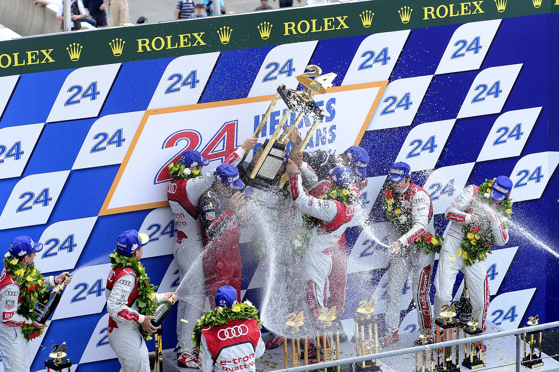LE MANS, FRANCE - JUNE 17:  Andre Lotterer of Germany, Marcel Fassler of Switzterland, and Benoit Treluyer of France, drivers of the #1 Audi R18 e-tron quattro, celebrate on the podium after winning the 80th running of the Le Mans 24 Hour race at the Circuit des 24 Heures du Mans on June 17, 2012 in Le Mans, France. (Photo by Rick Dole/Getty Images)