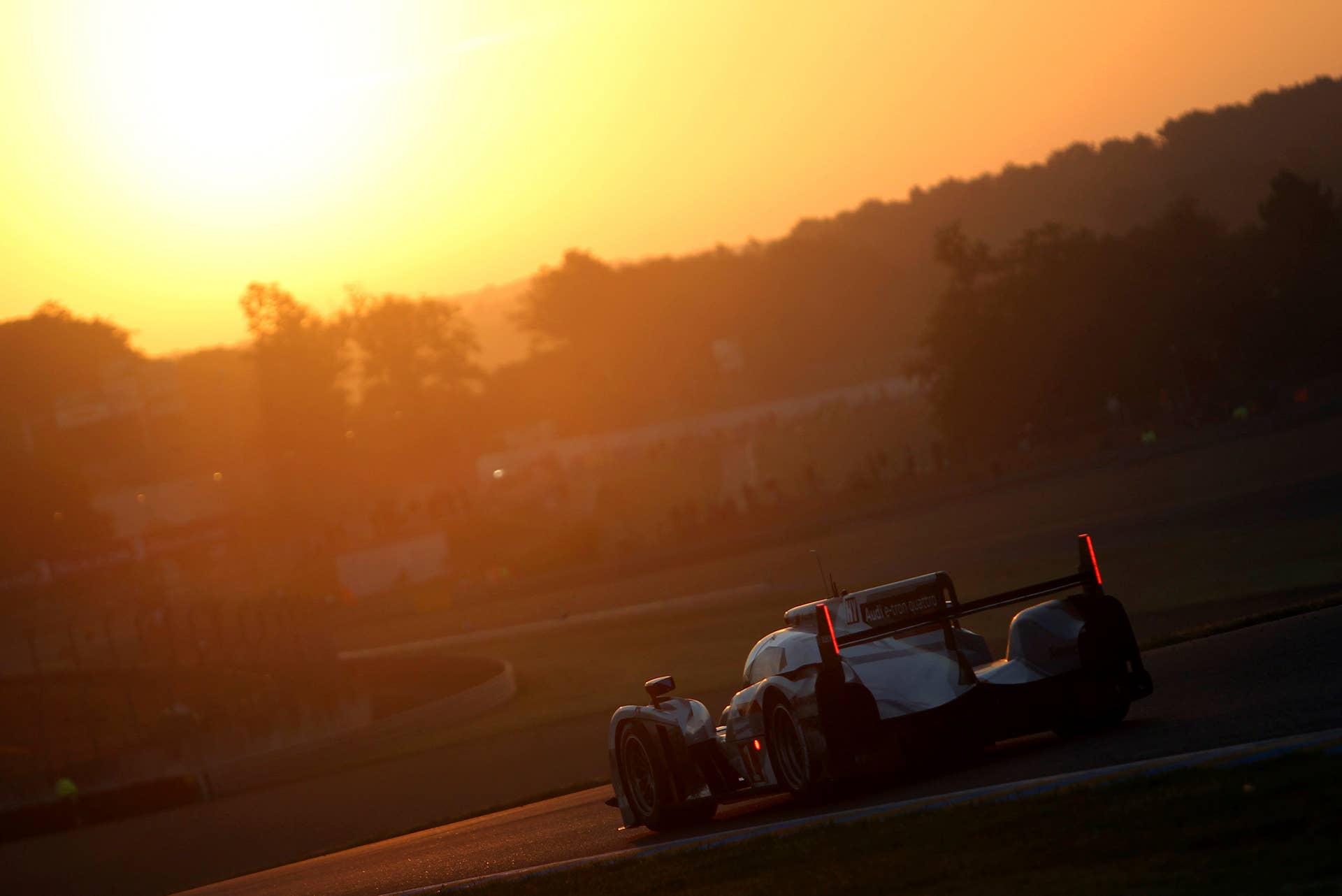 The Audi R18 e-tron No. 1 driven by Andre Lotterer of Germany is seen in action at daybreak during the 80th 24-hour Le Mans endurance race, in Le Mans, western France, Sunday, June 17, 2012. (AP Photo/David Vincent)