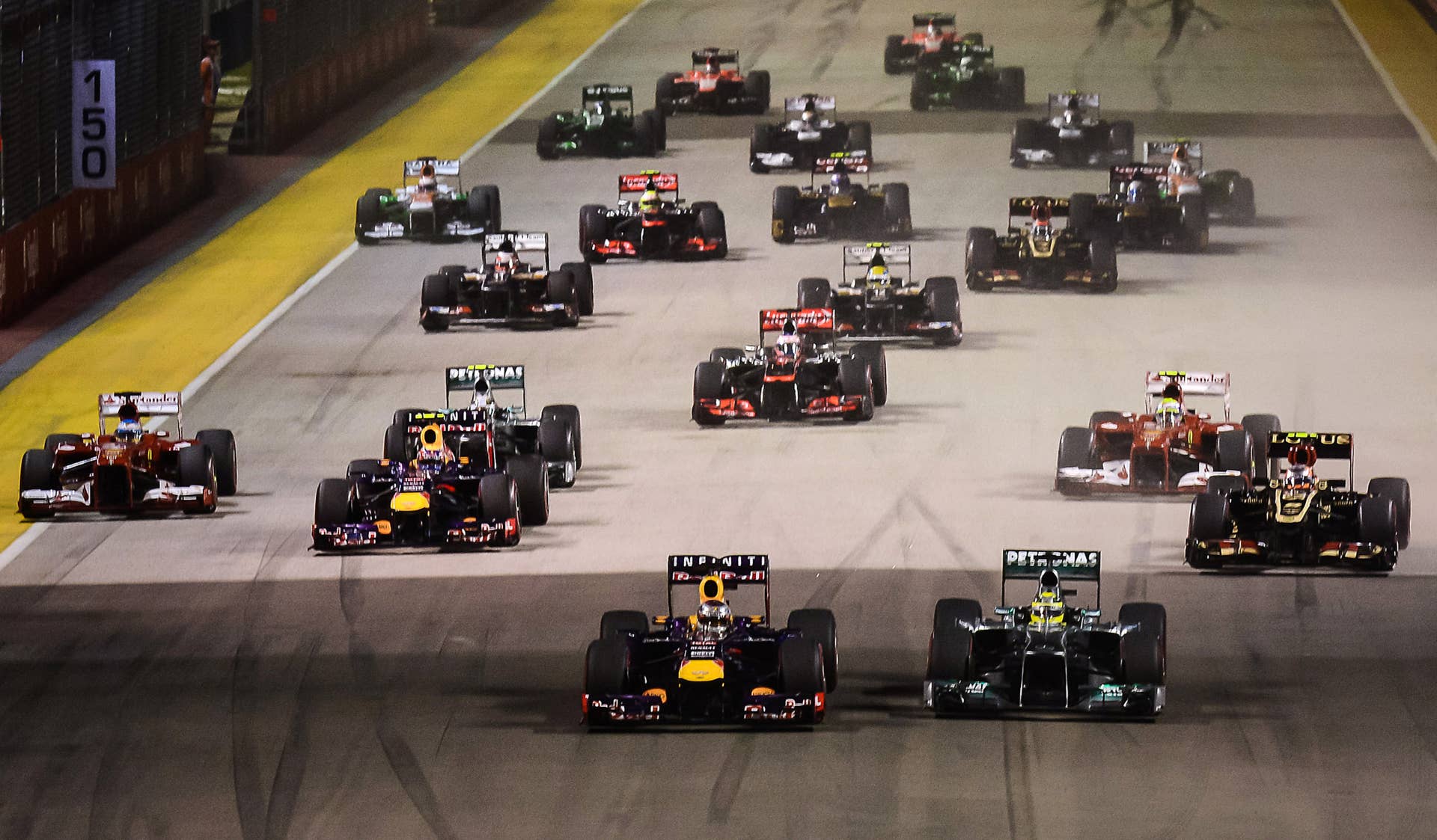 Cars come down the straight at the start of the Formula One Singapore Grand Prix in Singapore on September 22, 2013. AFP PHOTO / Philippe Lopez (Photo credit should read PHILIPPE LOPEZ/AFP/Getty Images)