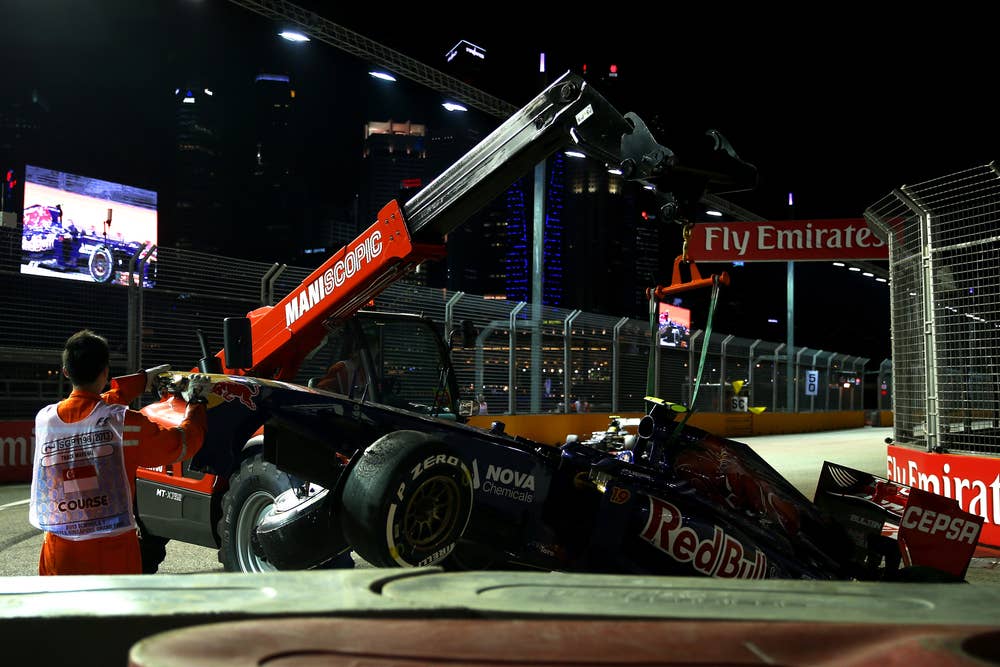 SINGAPORE - SEPTEMBER 22:  The wrecked car of Daniel Ricciardo of Australia and Scuderia Toro Rosso is recovered after crashing into a barrier during the Singapore Formula One Grand Prix at Marina Bay Street Circuit on September 22, 2013 in Singapore, Singapore.  (Photo by Mark Thompson/Getty Images)