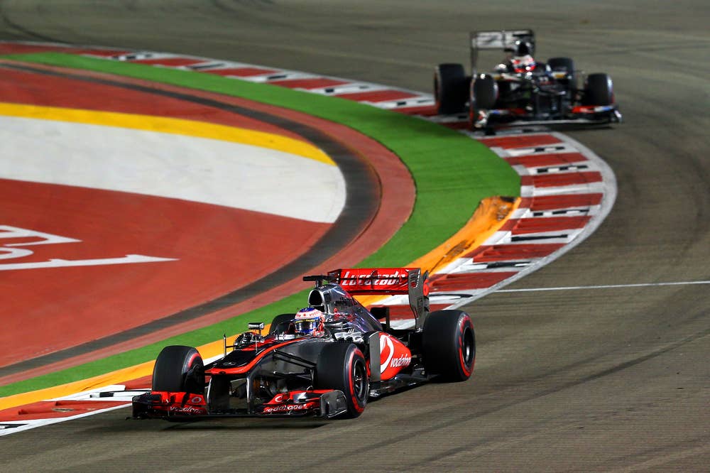 SINGAPORE - SEPTEMBER 22: Jenson Button of Great Britain and McLare is followed by Nico Hulkenberg of Germany and Sauber F1 during the Singapore Formula One Grand Prix at Marina Bay Street Circuit on September 22, 2013 in Singapore, Singapore.