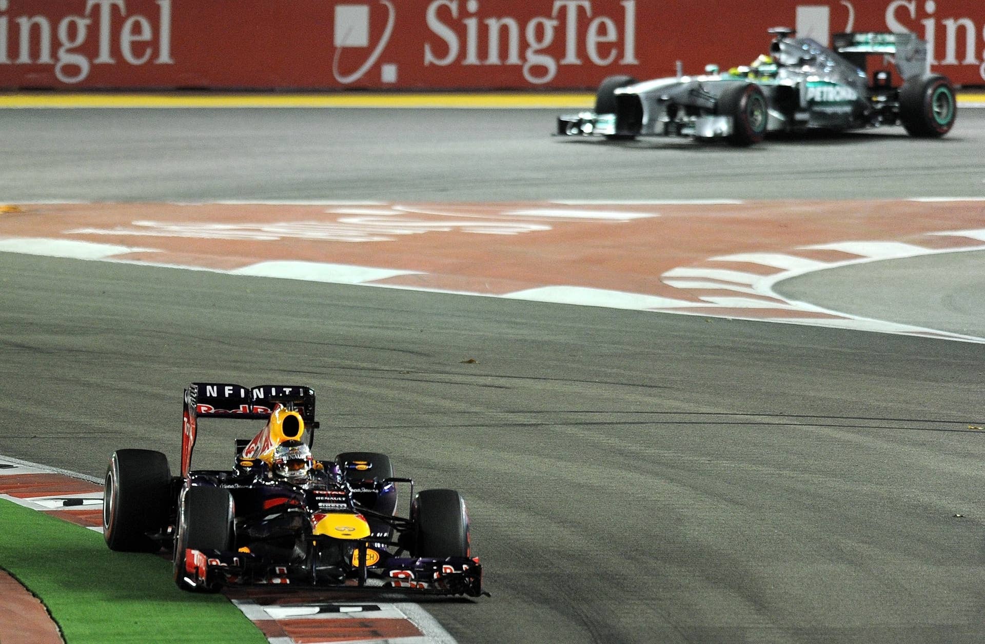 Red Bull-Renault driver Sebastian Vettel of Germany (L) leads in front of Mercedes driver Nico Rosberg of Germany (R) during the Formula One Singapore Grand Prix on September 22, 2013.   AFP PHOTO /  MANAN VATSYAYANA        (Photo credit should read MANAN VATSYAYANA/AFP/Getty Images)
