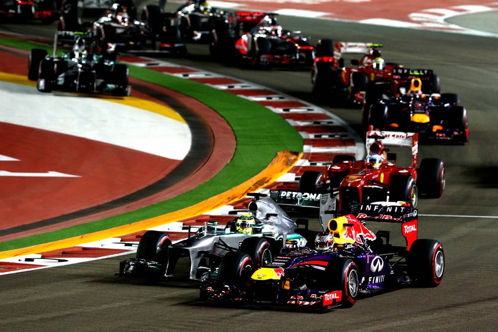 SINGAPORE - SEPTEMBER 22:Sebastian Vettel of Germany and Infiniti Red Bull leads Nico Rosberg of Germany and Mercedes GP into turn three during the Singapore Formula One Grand Prix at Marina Bay Street Circuit on September 22, 2013 in Singapore, Singapore.