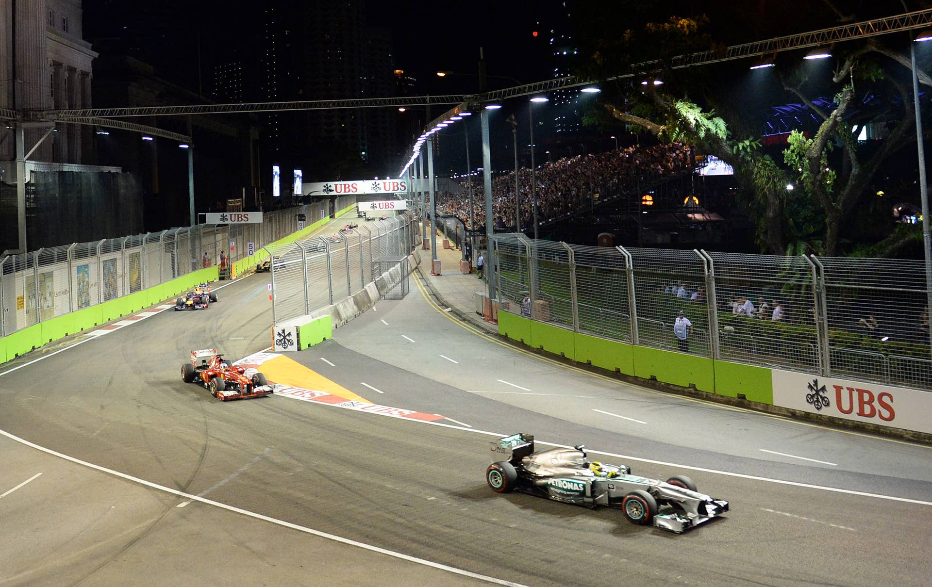 Mercedes driver Nico Rosberg of Germany (R) powers his car during the Formula One Singapore Grand Prix on September 22, 2013.   AFP PHOTO / ROSLAN RAHMAN        (Photo credit should read ROSLAN RAHMAN/AFP/Getty Images)
