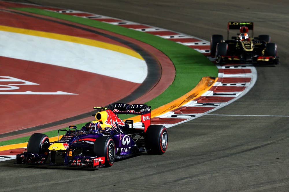 SINGAPORE - SEPTEMBER 22: Mark Webber of Australia and Infiniti Red Bull racing is followed by Romain Grosjean of France and Lotus GP during the Singapore Formula One Grand Prix at Marina Bay Street Circuit on September 22, 2013 in Singapore, Singapore.