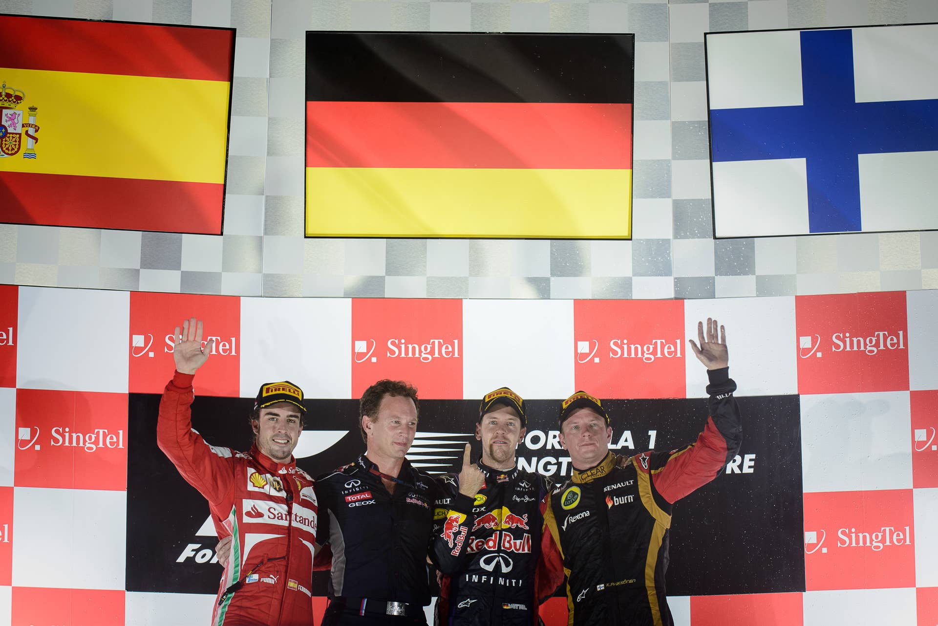 Red Bull driver Sebastian Vettel (2nd R) of Germany celebrates his victory on the podium between third-placed Lotus driver Kimi Raikkonen of Finland (R) and second-placed Ferrari driver Fernando Alonso of Spain (L) after the Formula One Singapore Grand Prix on September 22, 2013.   AFP PHOTO / Philippe Lopez        (Photo credit should read PHILIPPE LOPEZ/AFP/Getty Images)