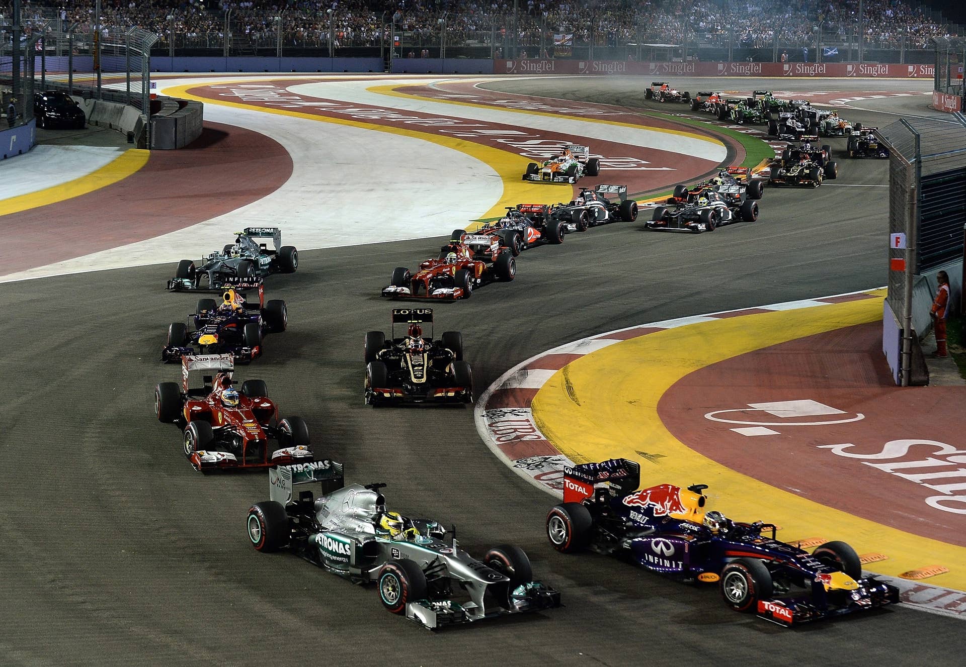 Red Bull-Renault driver Sebastian Vettel of Germany (R) leads the pack at the start of the Formula One Singapore Grand Prix on September 22, 2013.   AFP PHOTO /  MANAN VATSYAYANA        (Photo credit should read MANAN VATSYAYANA/AFP/Getty Images)