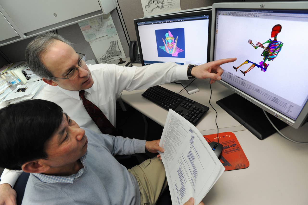 Steve Rouhana points out one of the intricacies of Ford's adult digital human model to researcher Jesse Ruan. Rouhana is the Senior Technical Leader for Safety, Ford Research and Advanced Engineering. (03/31/2011)