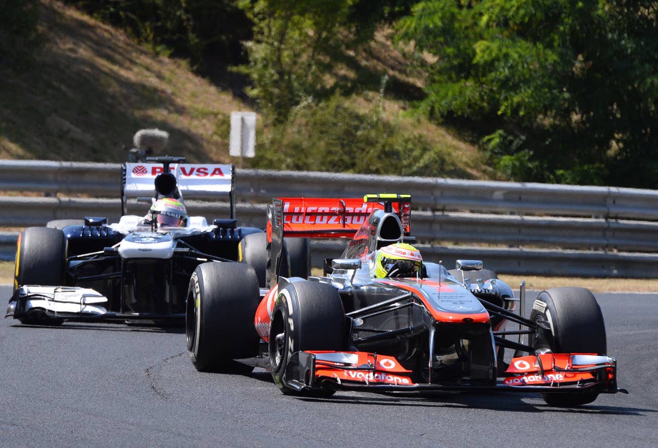 William's Venezuelan driver Pastor Maldonado (L) and McLaren Mercedes' Mexican driver Sergio Perez drive at the Hungaroring circuit in Budapest on July 28, 2013 during the Hungarian Formula One Grand Prix.    AFP PHOTO / ATTILA KISBENEDEKATTILA KISBENEDEK/AFP/Getty Images
