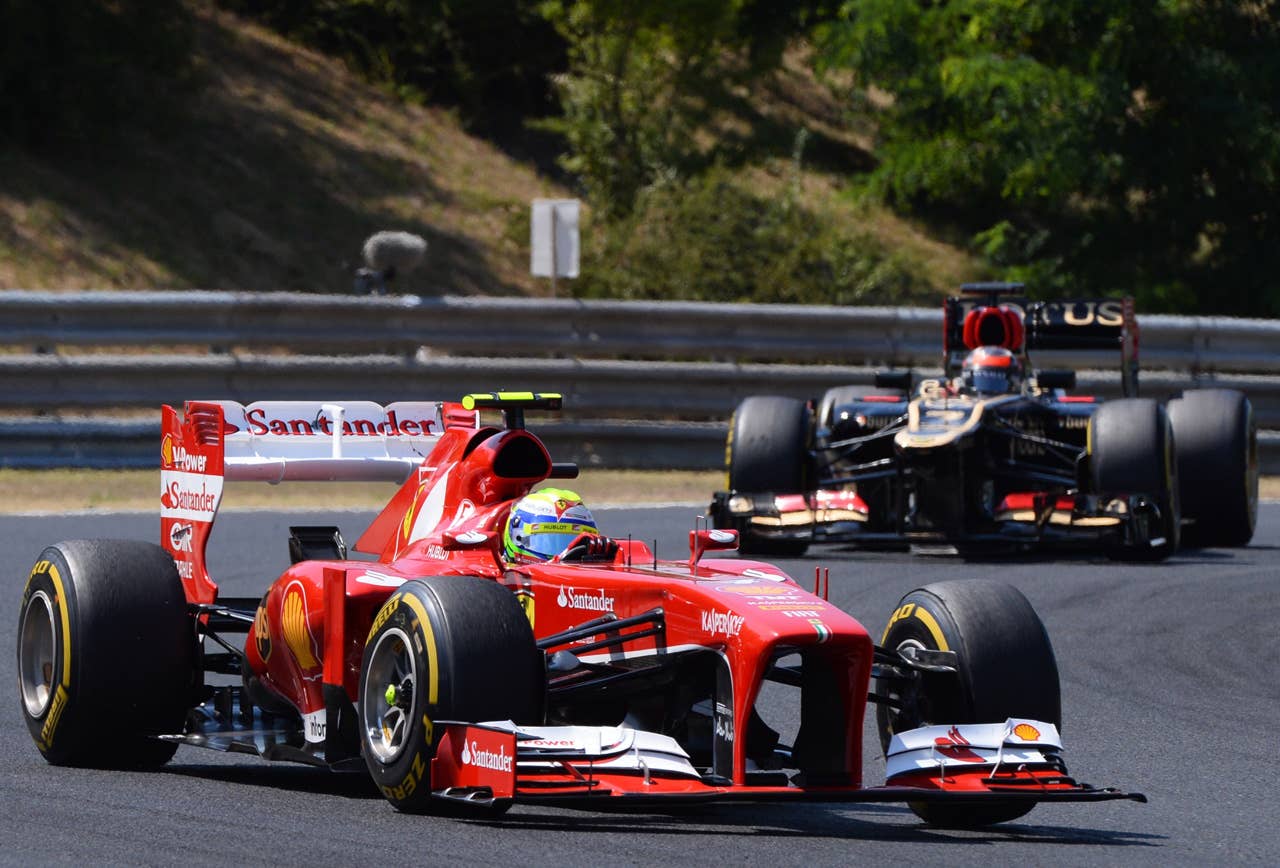 (L to R) Ferrari's Brazilian driver Felipe Massa and Lotus F1 Team's Finnish driver Kimi Raikkonen  drive at the Hungaroring circuit in Budapest on July 28, 2013 during the Hungarian Formula One Grand Prix.    AFP PHOTO / ATTILA KISBENEDEKATTILA KISBENEDEK/AFP/Getty Images
