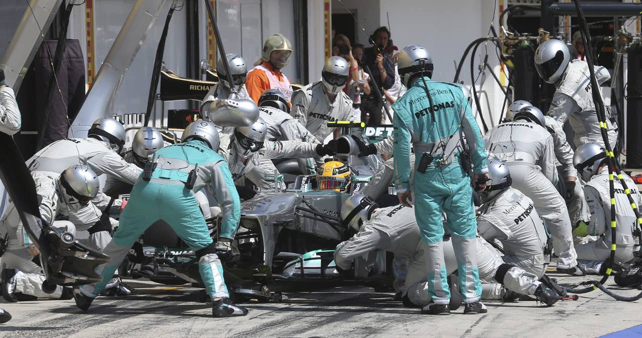 Mechanics change tires on the car of Mercedes'  British driver Lewis Hamilton in the pits at the Hungaroring circuit in Budapest on July , 2013 during the Hungarian Formula One Grand Prix.  AFP PHOTO / LUCA BRUNOLUCA BRUNO/AFP/Getty Images