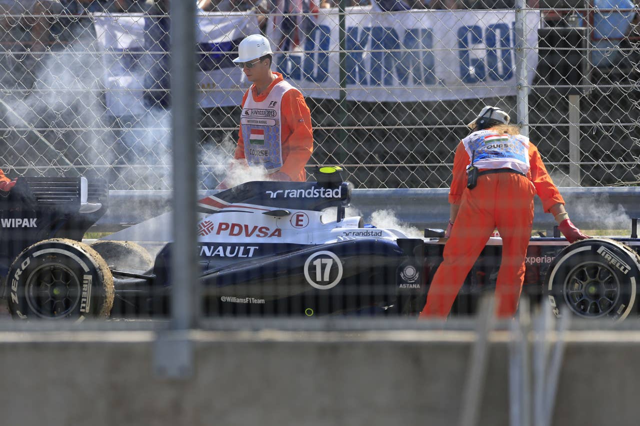 Track marshalls remove the car of Williams' Finnish driver Valtteri Bottas at the Hungaroring circuit in Budapest on July 28, 2013 during the Hungarian Formula One Grand Prix. AFP PHOTO / ALEXANDER KLEINALEXANDER KLEIN/AFP/Getty Images