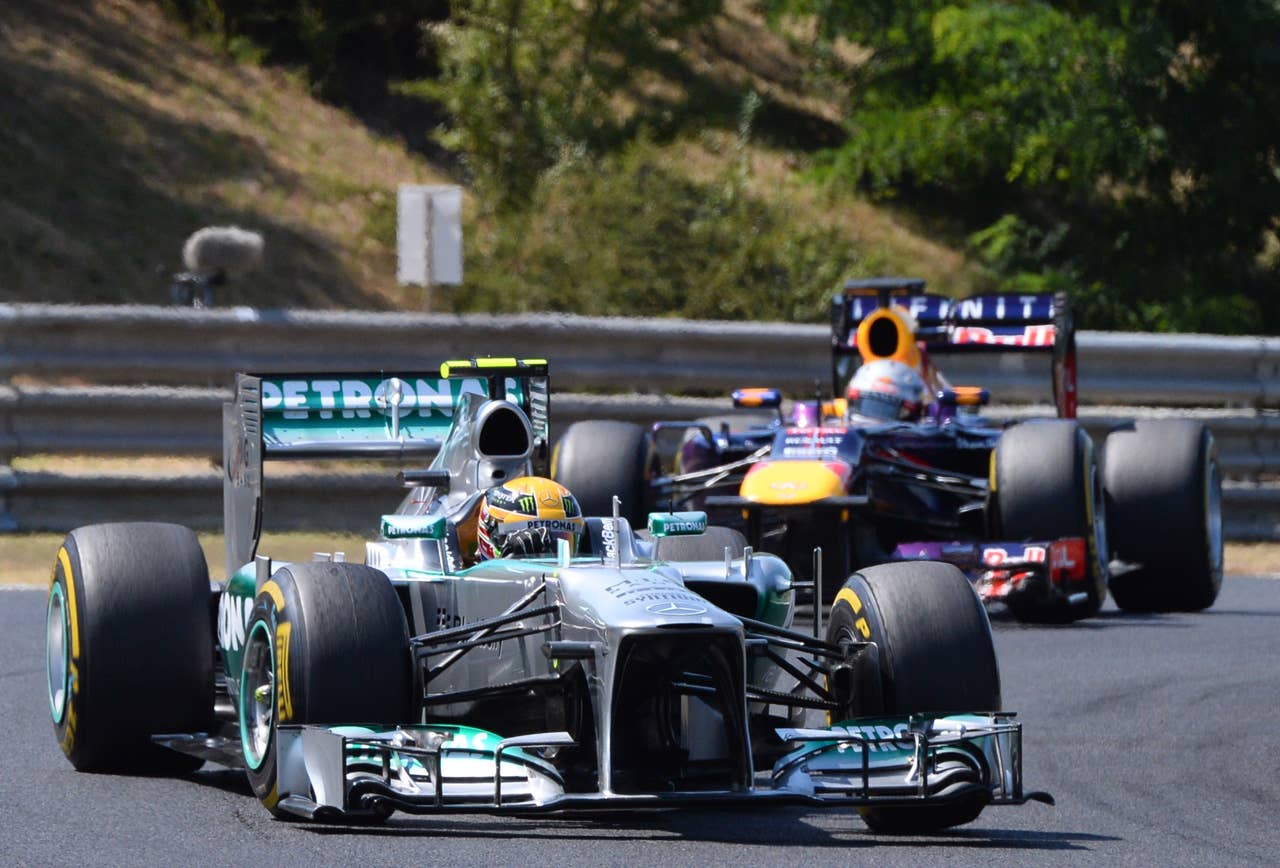 (L to R) Mercedes'  British driver Lewis Hamilton and Red Bull Racing's German driver Sebastian Vettel  drive at the Hungaroring circuit in Budapest on July 28, 2013 during the Hungarian Formula One Grand Prix.    AFP PHOTO / ATTILA KISBENEDEKATTILA KISBENEDEK/AFP/Getty Images