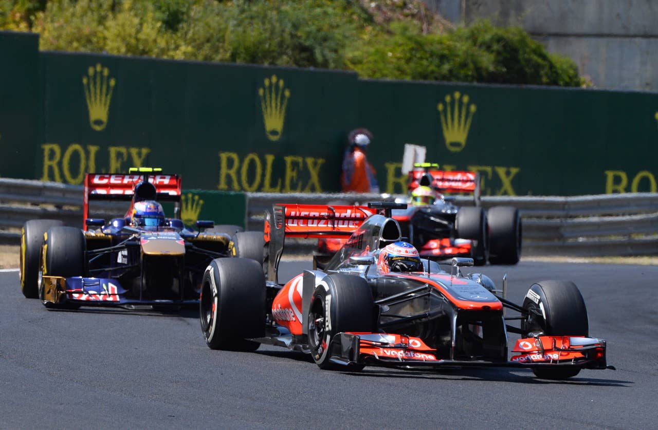 (L to R) Scuderia Toro Rosso's Australian driver Daniel Ricciardo, McLaren Mercedes' British driver Jenson Button and McLaren Mercedes' Mexican driver Sergio Perez drive at the Hungaroring circuit in Budapest on July 28, 2013 during the Hungarian Formula One Grand Prix.    AFP PHOTO / ATTILA KISBENEDEKATTILA KISBENEDEK/AFP/Getty Images