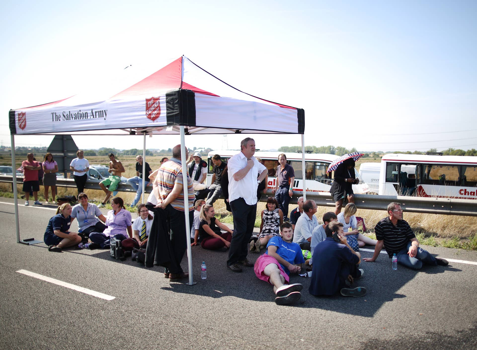 ISLE OF SHEPPEY, KENT - SEPTEMBER 05:  Drivers shelter from the sun under a tent provided by The Salvation Army as they wait to recover their vehicles after a major traffic accident on the A249 Sheppey crossing bridge in Kent on September 5, 2013 in Isle of Sheppey, Kent. Over 130 vehicles were involved in the series of accidents, with thick fog blamed for poor visibility. The crash occurred around 07:15AM BST, with at least 8 people suffering serious injuries, and approximately 60 people treated for minor injuries.  (Photo by Peter Macdiarmid/Getty Images)