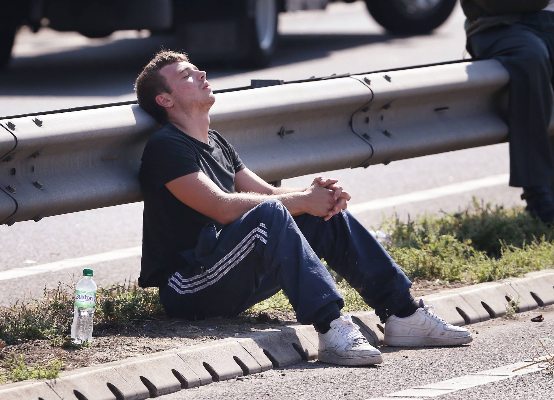 ISLE OF SHEPPEY, KENT - SEPTEMBER 05: A driver waits by the side of the road for his vehicle to be recovered after a major traffic accident on the A249 Sheppey crossing bridge in Kent on September 5, 2013 in Isle of Sheppey, Kent. Over 130 vehicles were involved in the series of accidents, with thick fog blamed for poor visibility. The crash occurred around 07:15AM BST, with at least 8 people suffering serious injuries, and approximately 60 people treated for minor injuries. (Photo by Peter Macdiarmid/Getty Images)
