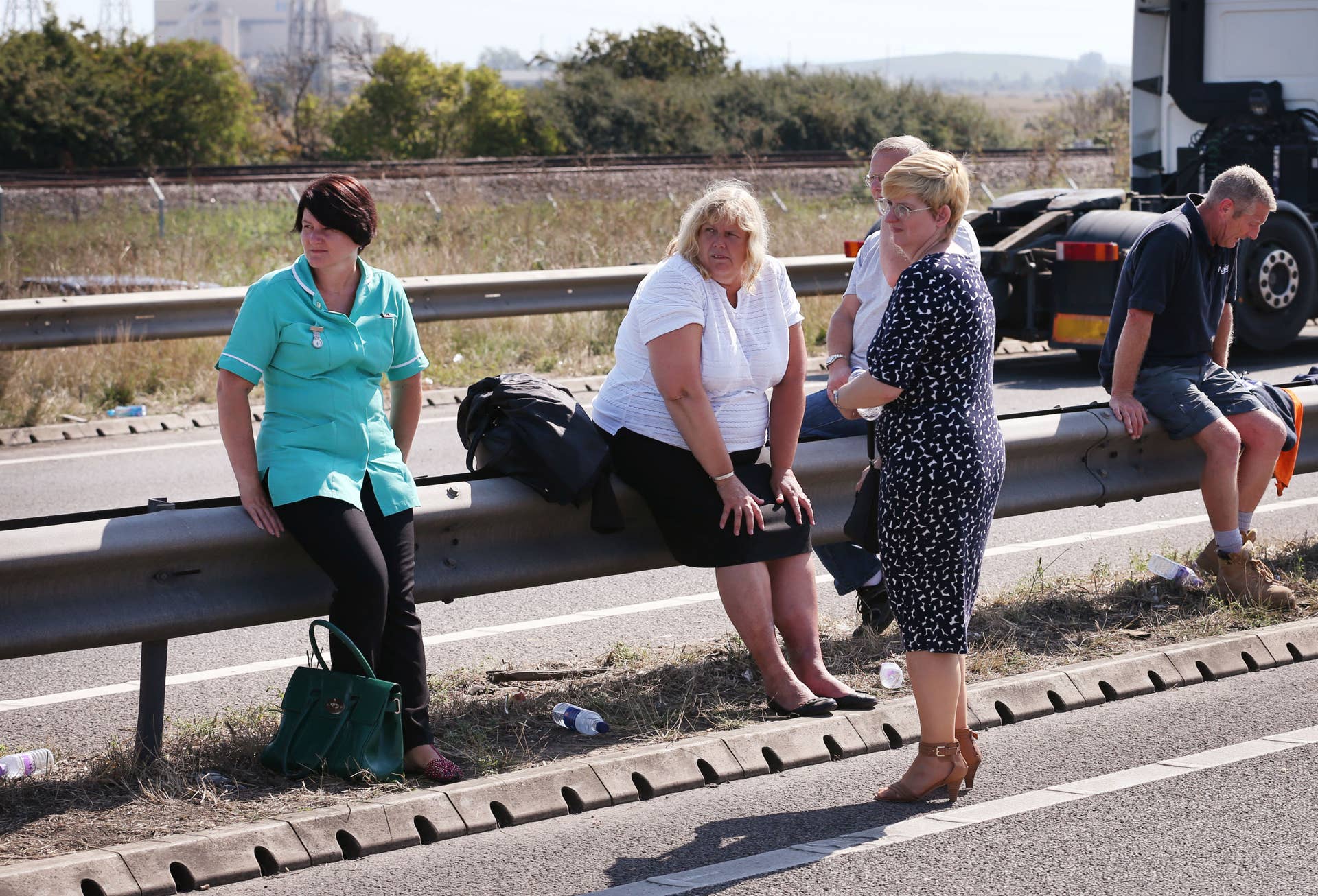 ISLE OF SHEPPEY, KENT - SEPTEMBER 05:  Drivers wait  by the side of the road to recover their vehicles  after a major traffic accident on the A249 Sheppey crossing bridge in Kent on September 5, 2013 in Isle of Sheppey, Kent. Over 130 vehicles were involved in the series of accidents, with thick fog blamed for poor visibility. The crash occurred around 07:15AM BST, with at least 8 people suffering serious injuries, and approximately 60 people treated for minor injuries.  (Photo by Peter Macdiarmid/Getty Images)