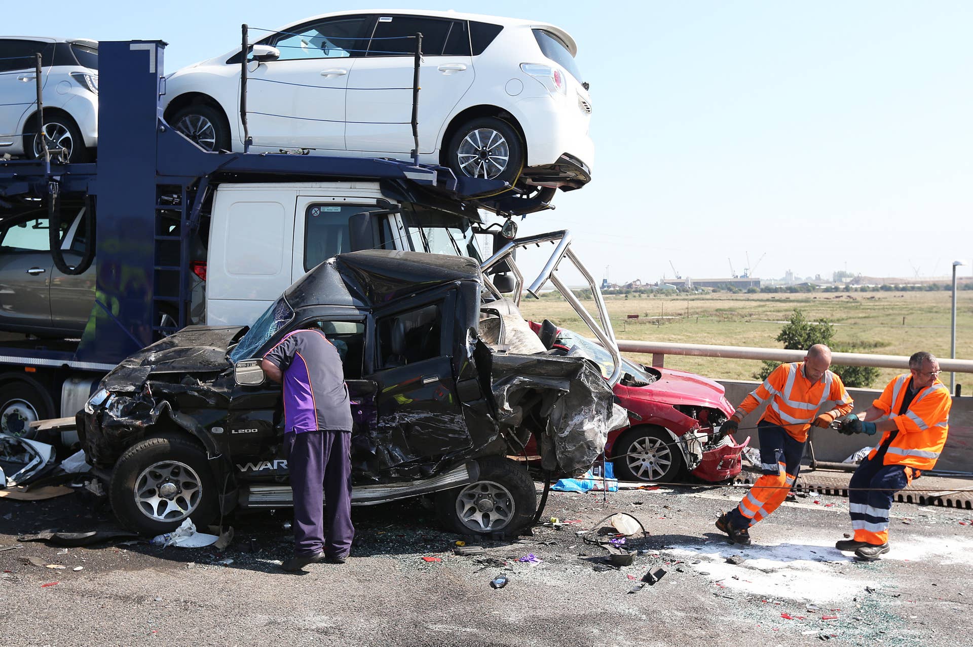 ISLE OF SHEPPEY, KENT - SEPTEMBER 05:  Vehicle recovery workers move a car at the site of a major traffic accident on the A249 Sheppey crossing bridge in Kent on September 5, 2013 in Isle of Sheppey, Kent. Over 130 vehicles were involved in the series of accidents, with thick fog blamed for poor visibility. The crash occurred around 07:15AM BST, with at least 8 people suffering serious injuries, and approximately 60 people treated for minor injuries.  (Photo by Peter Macdiarmid/Getty Images)